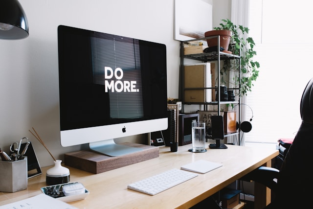 Computador em uma mesa com a seguinte mensagem na tela: 'Do more.'